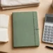 A home desk with bills, a notebook and a calculator