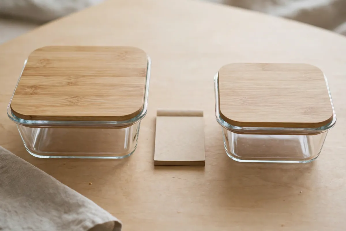Two similar everyday products placed side by side on a table for comparison, with a small notepad between them